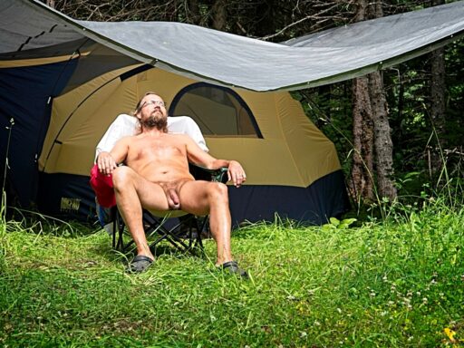 Naturist sitting in chair by a tent