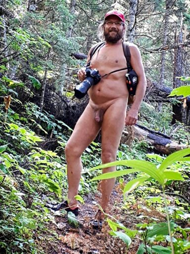 Shows a naturist posing on a trail